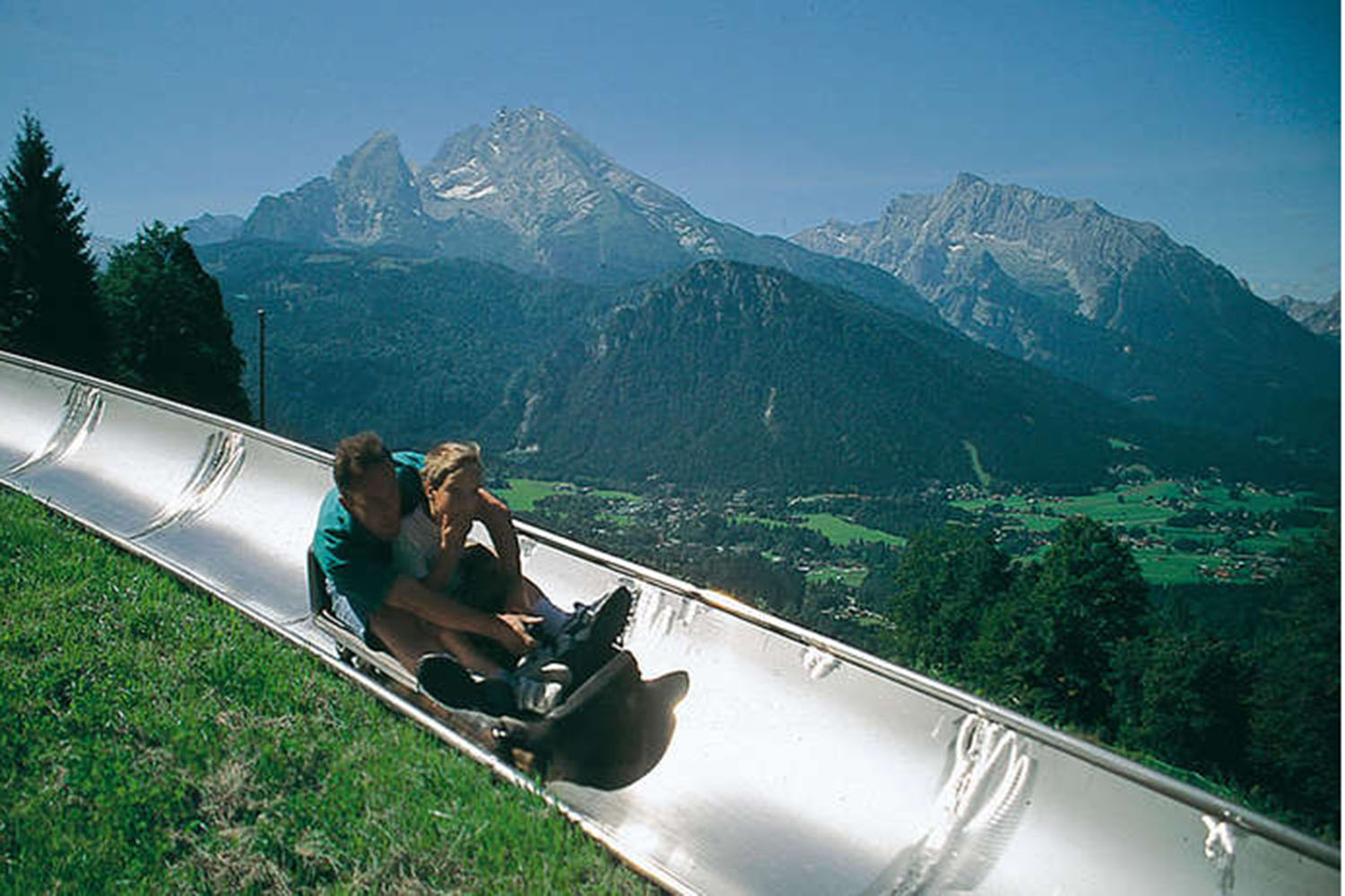Blick auf die Rodelbahn am Obersalzberg mit dem Berchtesgadener Talkessel, dem Watzmann und dem Hochkalter